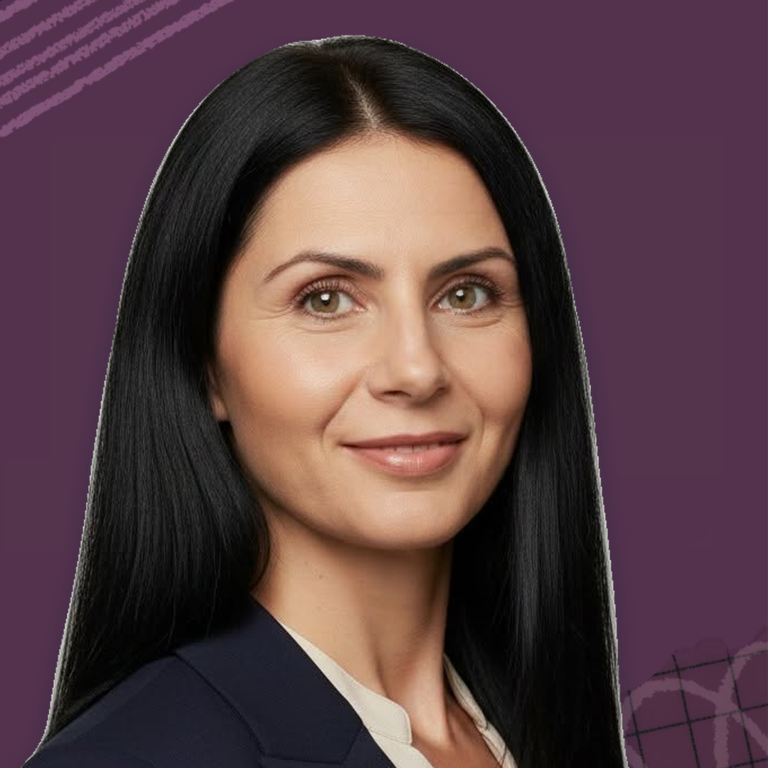 Портрет на усмихната жена с дълга тъмна коса и тъмносиньо сако на лилав фон